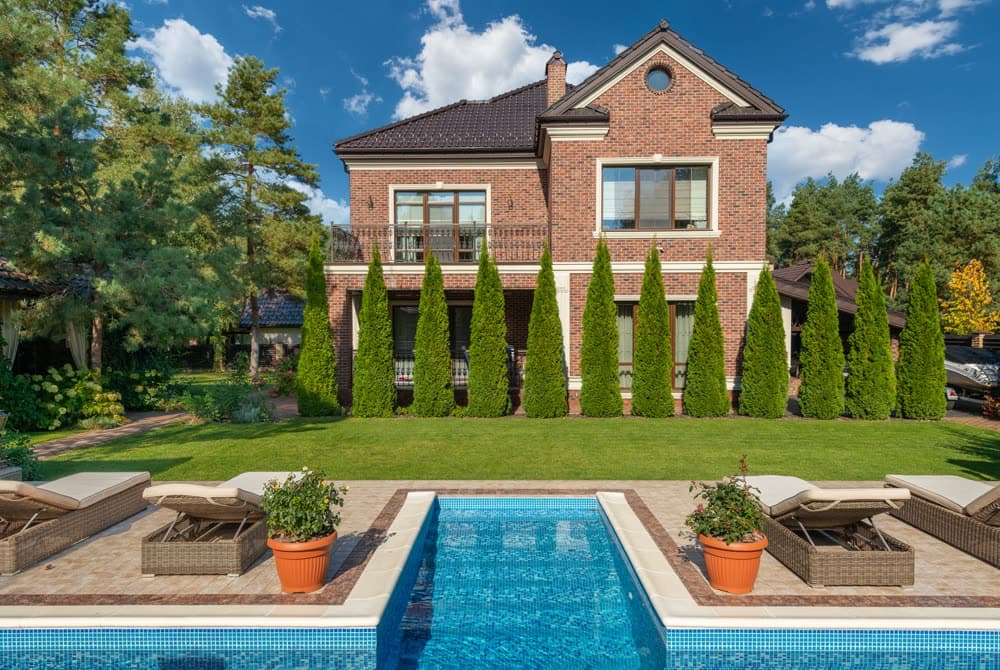 Backyard pool with terrace and lush landscaping