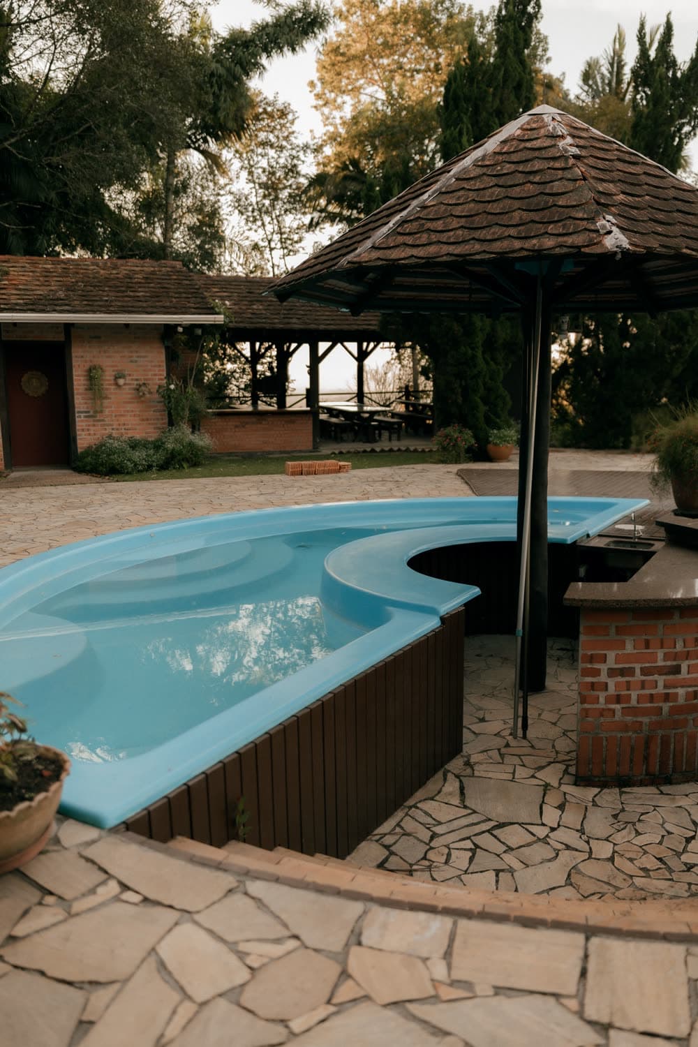 Curved pool with a patio and gazebo